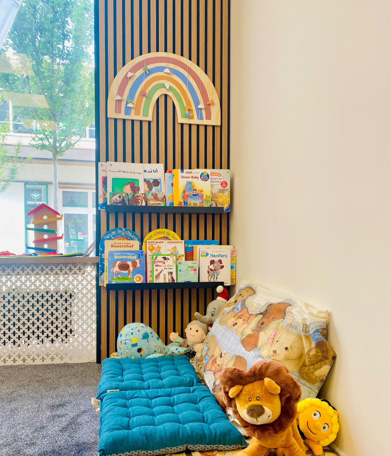 Gemütliche Leseecke mit Bilderbüchern und Kuscheltieren